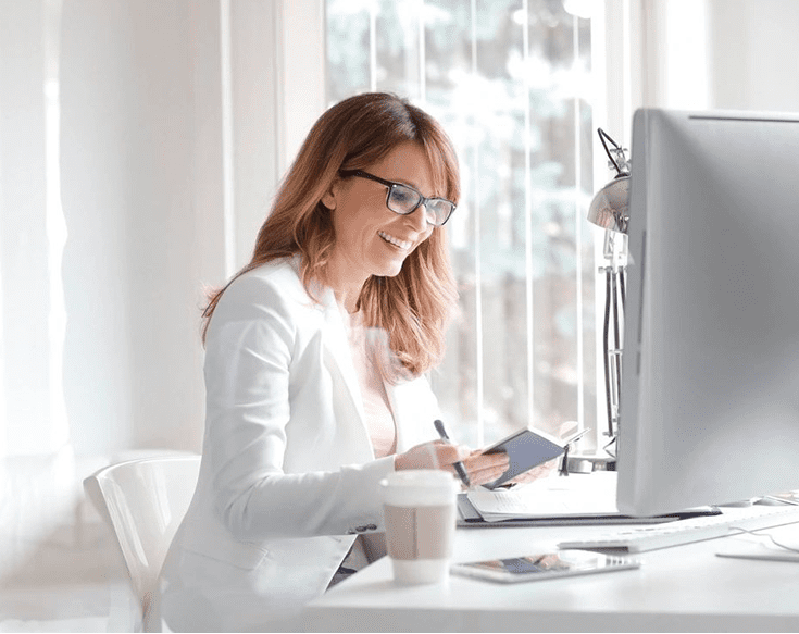 A woman sitting at a table with a cup of coffee.