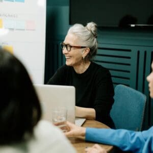 A group of people sitting at a table with laptops.