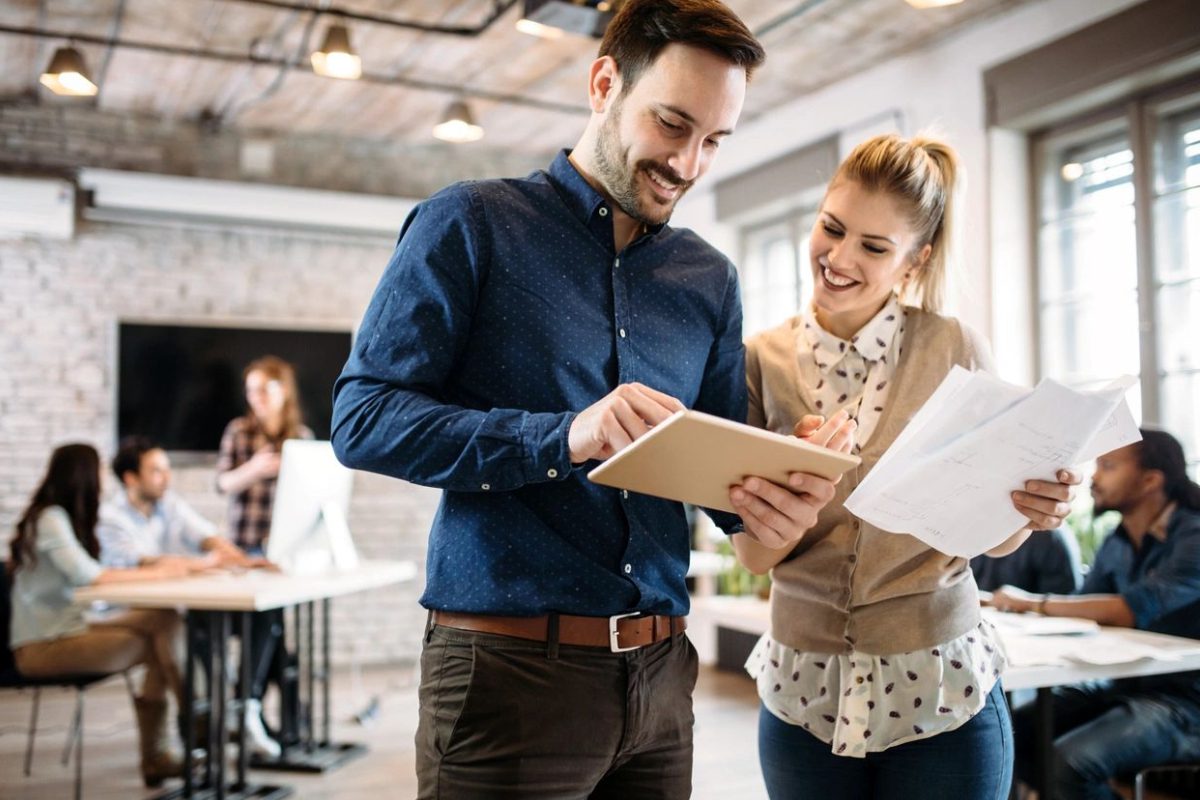 A man and woman looking at papers in an office.